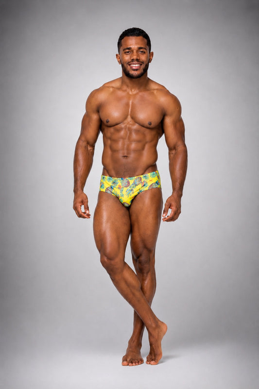 Brief Piñas Equal Swimwear — vista frontal, modelo sonriendo, estampado tropical amarillo