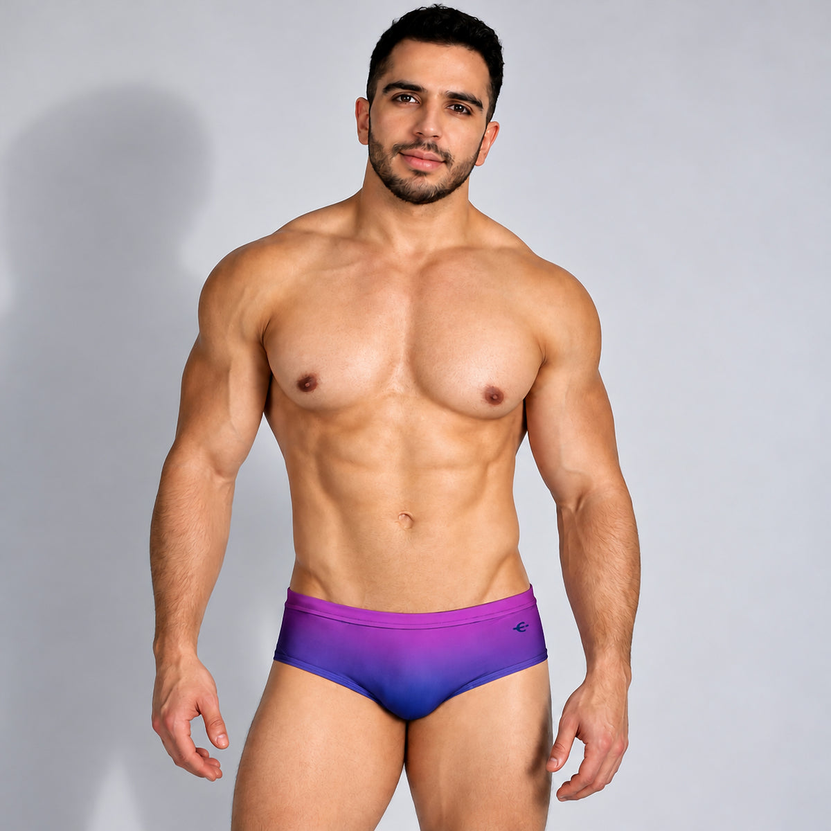 Traje de baño para hombre púrpura con degradado azul, vista frontal en modelo.