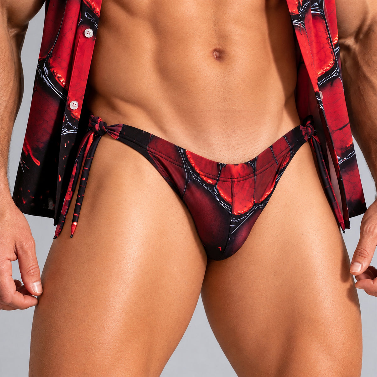 Bikini de baño para hombre rojo y negro, detalle del estampado de escamas y lazos laterales.
