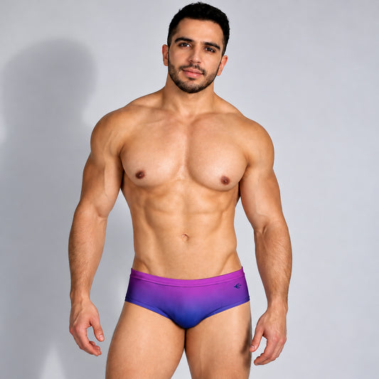 Traje de baño para hombre púrpura con degradado azul, vista frontal en modelo.