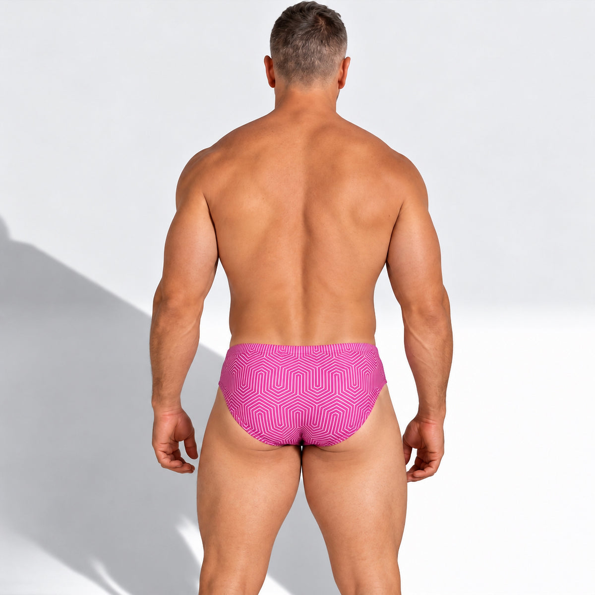 Vista posterior del traje de baño Brief Fresh rosa con estampado geométrico, puesto en modelo.