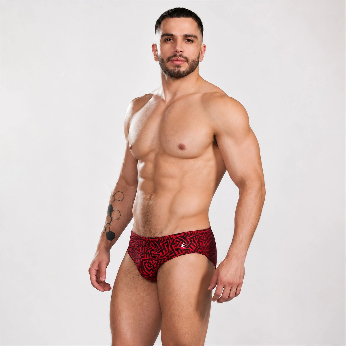 Men's swim briefs, side profile with red Grecas print by Equal Swimwear.