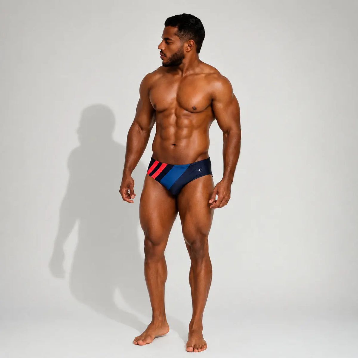 Brief de baño deportivo para hombre azul con franjas rojas, vista frontal – Brief Sport de EQUAL Swimwear