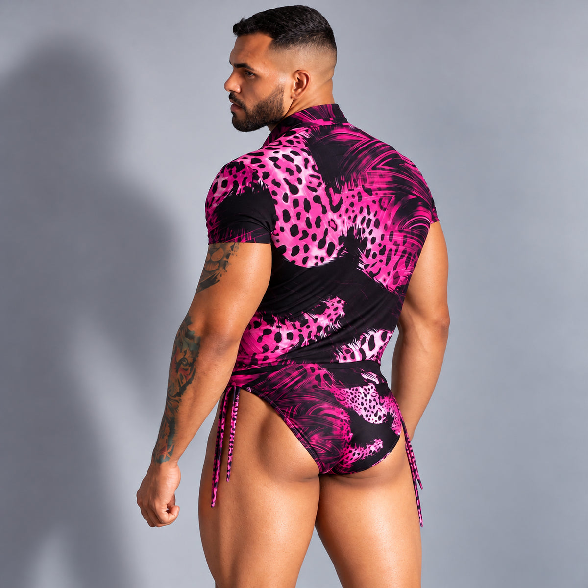 Conjunto de playa para hombre fucsia y negro, camisa y bikini estampados, vista trasera.